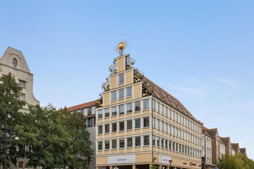 a building with a tower on top of it at Vienna House by Wyndham Sonne Rostock in Rostock