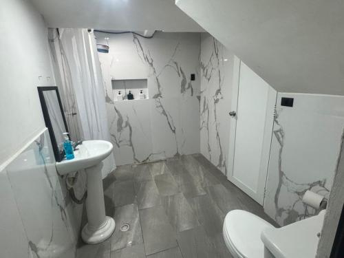 a white bathroom with a sink and a toilet at Casa KM222 in Esquipulas