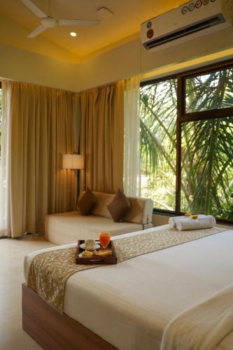 a bedroom with two beds and a large window at Oceanature Alibaug in Alibaug