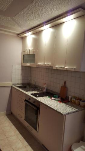 a kitchen with white cabinets and a sink at Vila D&D in Zlatibor