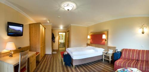 a hotel room with a bed and a couch at Das Pfandler in Pertisau