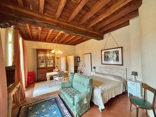 a bedroom with a bed and a chair and a table at Antica Casa Fenaroli in Iseo