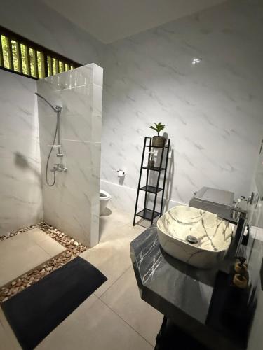 a bathroom with a sink and a shower and a toilet at Sunset Villa in Senggigi