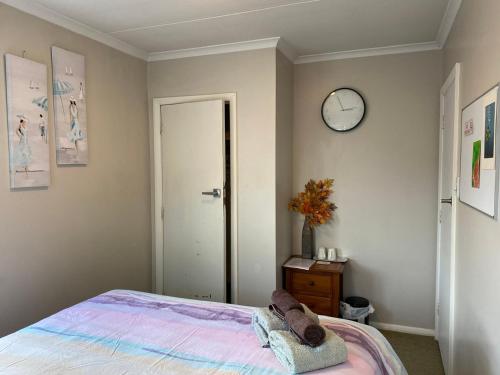 a bedroom with a bed and a clock on the wall at A convenient stay in Hamilton