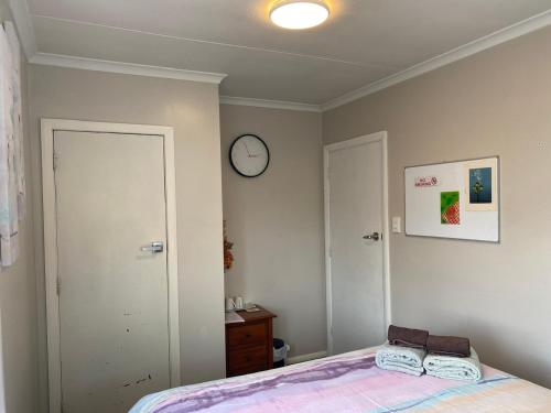 a bedroom with a bed and a clock on the wall at A convenient stay in Hamilton