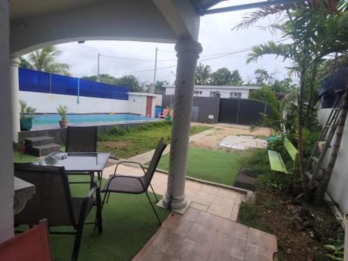 a patio with a table and chairs and a pool at Blue Horizon Villa in Grand Baie in Grand-Baie