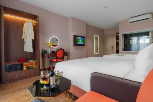 a hotel room with a large bed and a table at Sono Sallute Luxury Hotel in Ho Chi Minh City