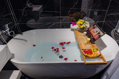 a bath tub with a tray of food and flowers at Sono Sallute Luxury Hotel in Ho Chi Minh City