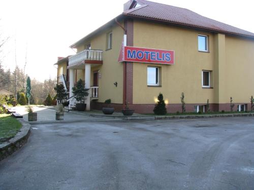 a hotel with a motel sign on the side of a road at Piligrimo Užeiga in Kadarės