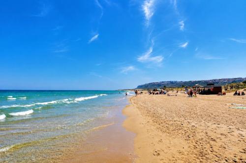a beach with people and the ocean on a sunny day at Beachfront Luxury Apartments by NRAS in Arenales del Sol