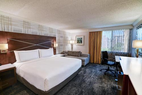 a hotel room with a large bed and a couch at DoubleTree by Hilton Madison Downtown in Madison