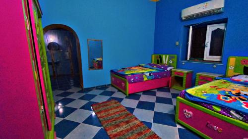 a childrens room with two beds and a mirror at The white House in Aswan