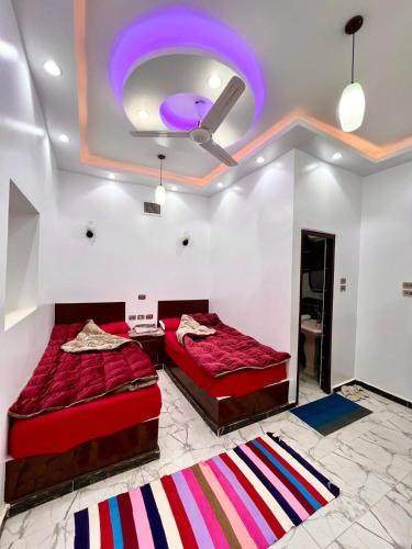 two beds in a room with a purple ceiling at The white House in Aswan
