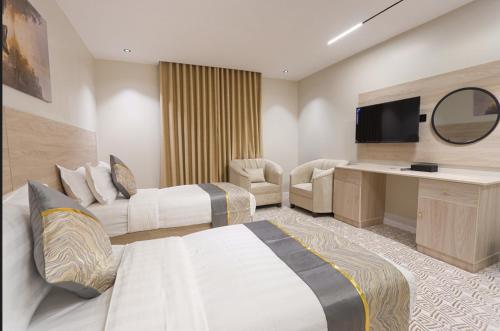 a hotel room with two beds and a flat screen tv at فندق سويتس لاين in Medina