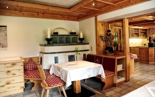 a dining room with a table and a fireplace at Gletscher-Landhaus Brunnenkogel in Sankt Leonhard im Pitztal