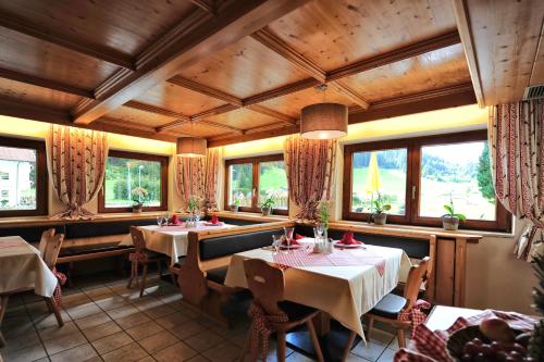 a restaurant with tables and chairs and windows at Gletscher-Landhaus Brunnenkogel in Sankt Leonhard im Pitztal