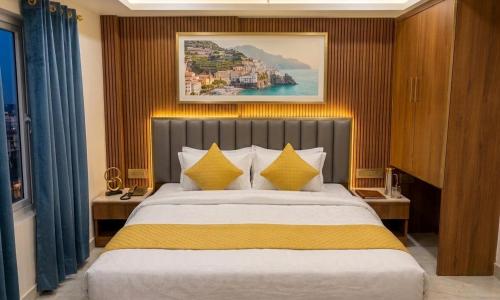 a bedroom with a large bed with yellow pillows at Hotel Banaras Vandanam in Varanasi