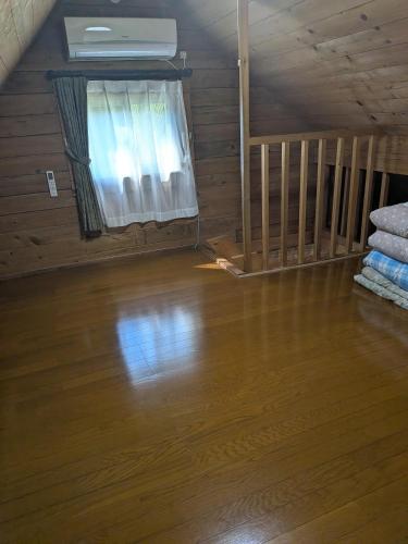 a room with a wooden floor and a window at のんびれっじ七草 in Nasushiobara