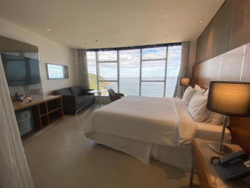 a hotel room with a bed and a view of the ocean at Hotel Nacional Rio in Rio de Janeiro