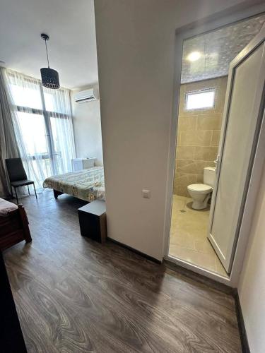 a room with a bed and a bathroom with a toilet at TheStarryNight in P'ichvnari