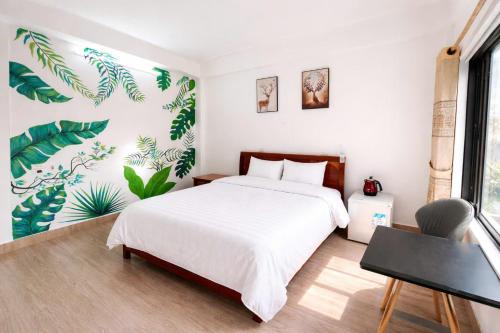a bedroom with a white bed and plants on the wall at Thao Nguyen Homestay in Phong Nha