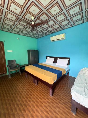 a bedroom with a bed in a blue room at Bhudda Lodge in Tirupati