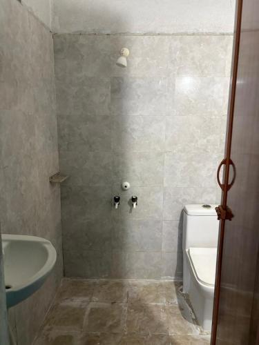 a bathroom with a tub and a toilet and a sink at Bhudda Lodge in Tirupati