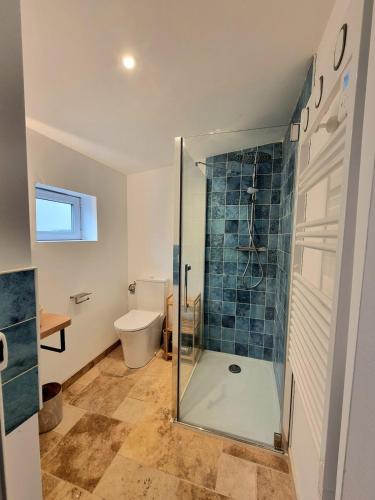 a bathroom with a glass shower with a toilet at Chez Simone in Ploemeur