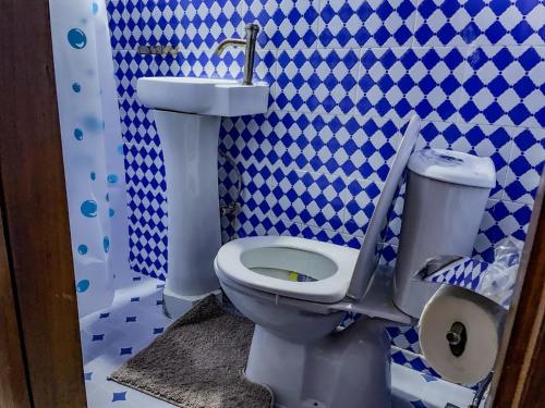 a blue and white bathroom with a toilet and a sink at Wiwi Appartement in Kinshasa