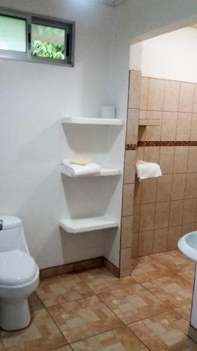 a bathroom with a toilet and a shower at Tropical Paradise Bungalows in Pital