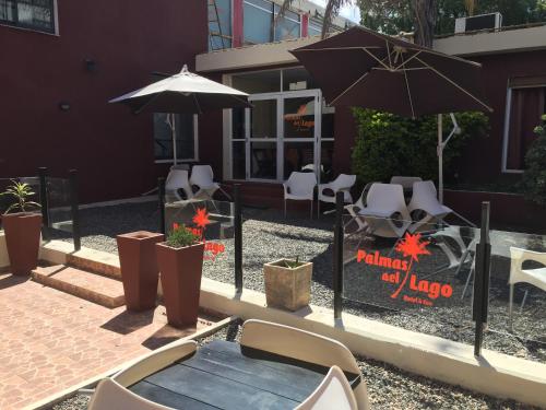 a patio with a table and chairs and an umbrella at Palmas del Lago in Villa Carlos Paz