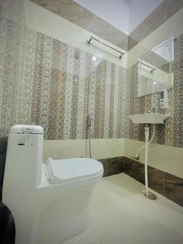 a bathroom with a toilet and a sink at Sky Hotel in Lucknow