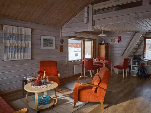 a living room with orange chairs and a table at Polar Tranquil Cabins in Kittilä