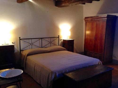 a bedroom with a bed and two lights on the wall at Agriturismo Villa Dauphiné in Bagno a Ripoli
