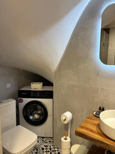 a bathroom with a washing machine and a sink at Litus Amoris 2 in Sidari