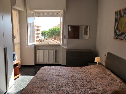 sypialnia z dużym łóżkiem i oknem w obiekcie House Roxana by Holiday World w mieście San Bartolomeo al Mare