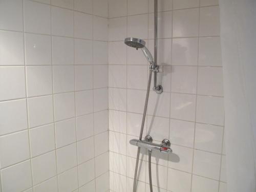 een douche met een douchekop in de badkamer bij B&B Vincent's Attic in Ede
