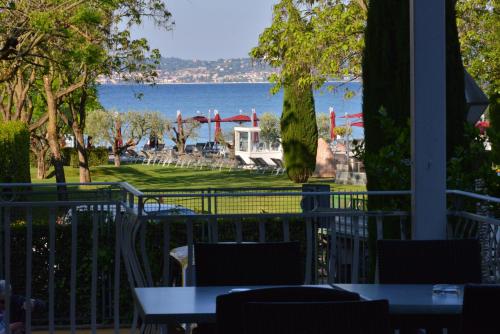 a view of the water from a restaurant with tables and chairs at Hotel Luna in Sirmione