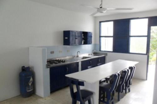 a kitchen with blue cabinets and a white counter top at Apartamentos Las Múcuras in Coveñas