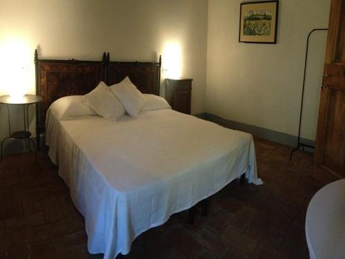 a bedroom with a white bed with two pillows at Agriturismo Villa Dauphiné in Bagno a Ripoli