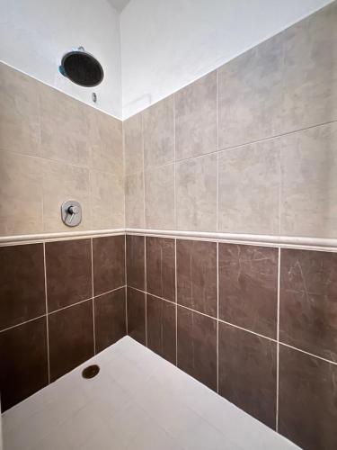 a bathroom with a shower with brown tiles at Vacation Villa Marina in Puerto Vallarta