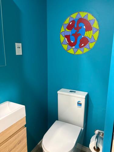a bathroom with a toilet and a plate on the wall at Ke's home in Wellington