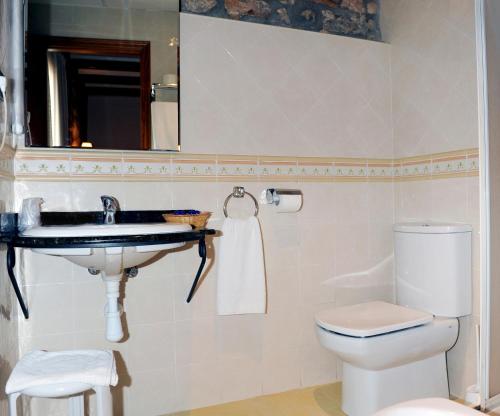 a bathroom with a sink and a toilet and a mirror at Hotel Restaurante Verdia in Sueras