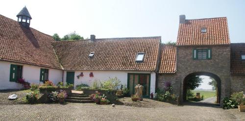 an old building with an archway in a yard at Bladelijn in Lampernisse