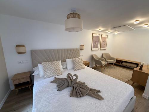 a bedroom with a white bed with a bow on it at El Rincón de Mateo in Combarro