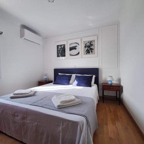 a bedroom with a large bed with blue pillows at Philoxenia Home in Áyios Pétros