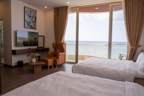 a hotel room with two beds and a view of the ocean at Mia Beach Hotel in Cù Lao Thu