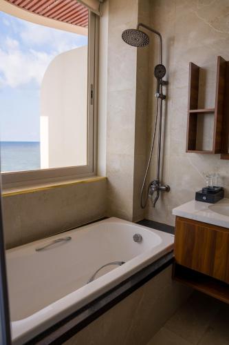 a bathroom with a bath tub and a window at Mia Beach Hotel in Cù Lao Thu
