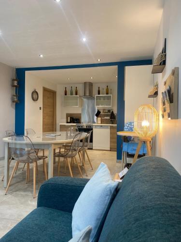 a living room and kitchen with a couch and a table at Gîte des oursons - Climatisé in Guyans-Durnes