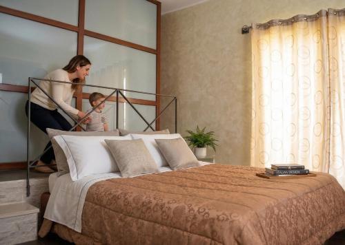 a woman and a child standing next to a bed at Meson Cavour in Avigliano